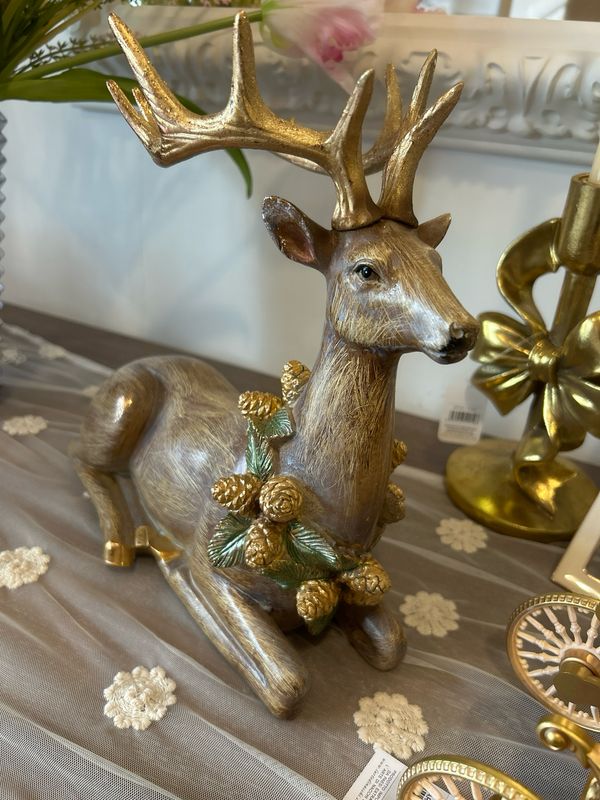 Renna seduta L.30H27 con corona pigna dorata Renna seduta L.30H27 con corona pigna dorata