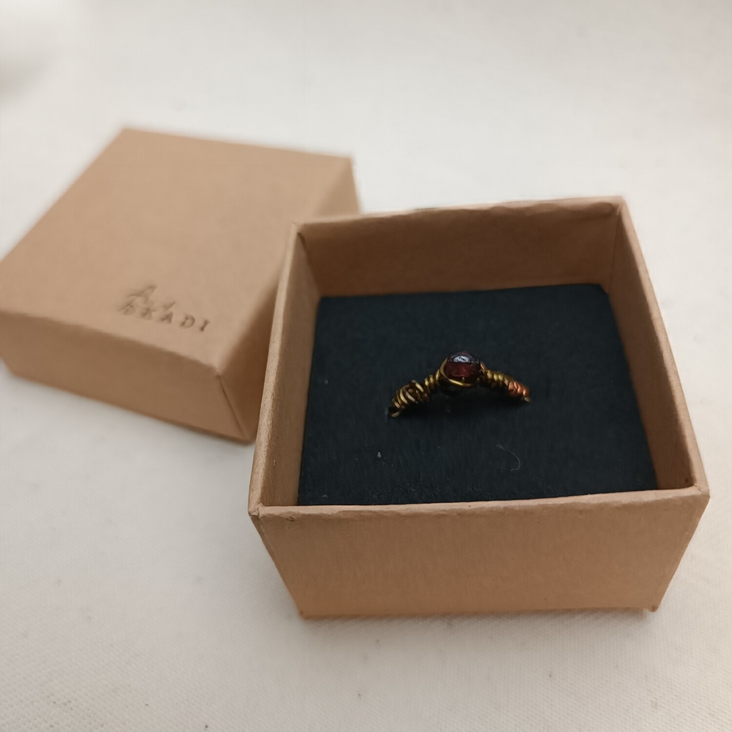 Messingfarbender Ring Gr.45 mit dunkelroten Stein