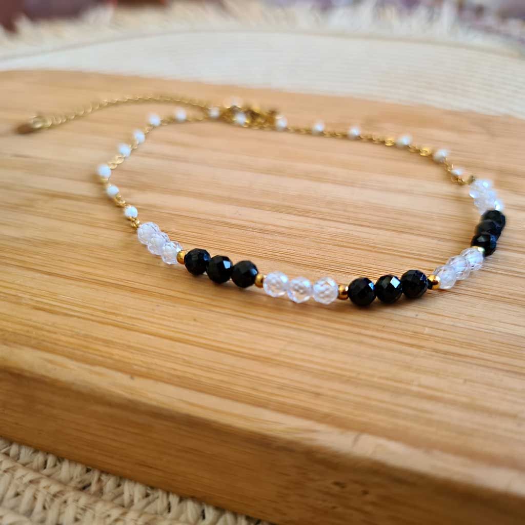 Tobillera de Circonita blanca y negra en acero dorado Pureza, Protección, Equilibrio.