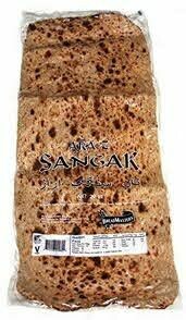 Sangak bread on a rustic wooden surface, showcasing its distinct oval shape, crispy golden-brown crust, and textured surface dotted with irregular air pockets, typical of this traditional Persian flatbread.