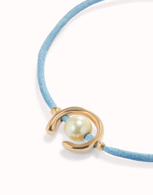 Pulsera de hilo azul con perla shell fornitura bañada en oro 18k.
