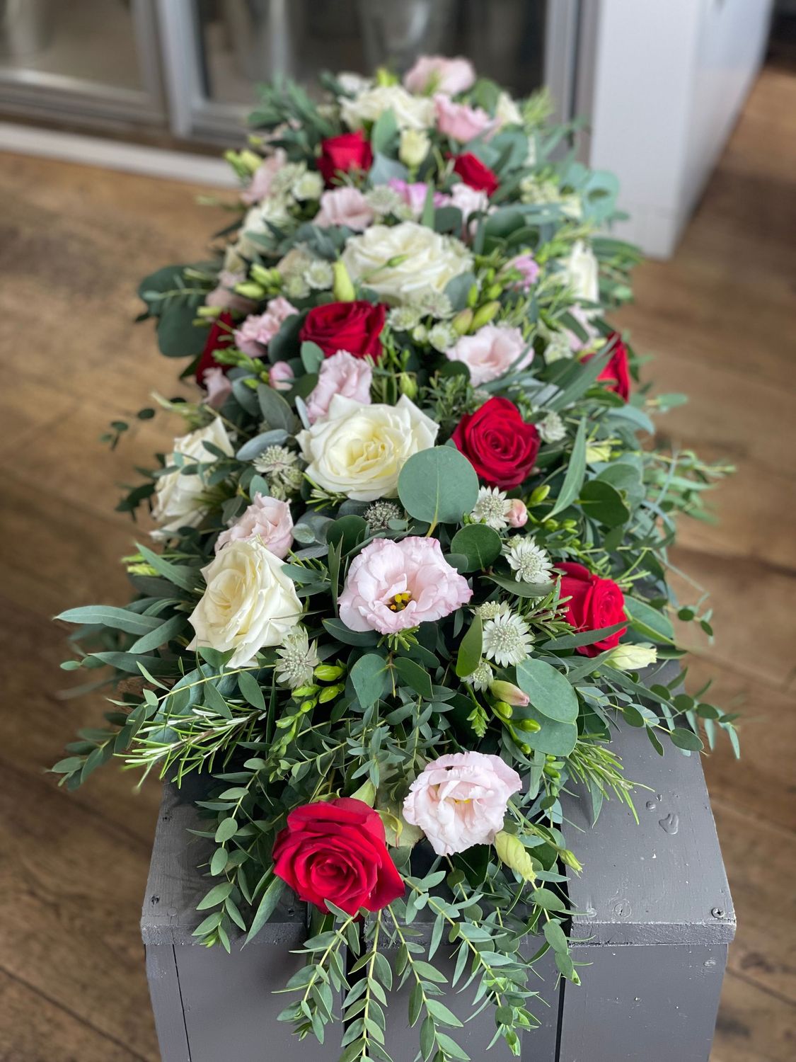 Casket spray red, white and soft pink