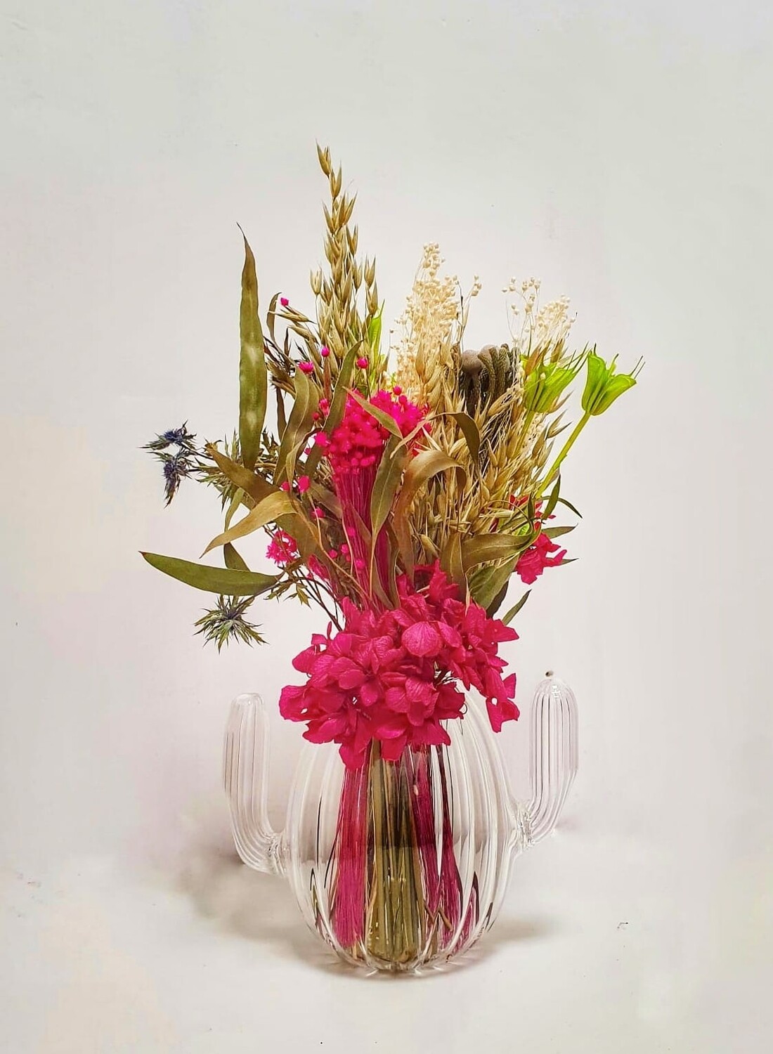 Jarron de cristal en forma de cactus con flores preservadas