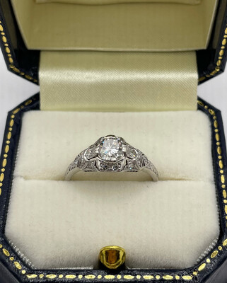 C.1920 Art Deco Platinum Engagement Ring With Brilliant Cut Diamond Centre Stone Aprox .75ct With Sixteen Little Diamonds Surrounding It.