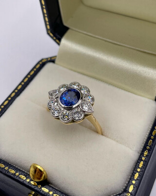 Stunning .90ct Oval Sapphire With 1.20ct Of Brilliant Cut Diamonds, Two Fluted Into A Petal Shape. Platinum Set On 18ct Yellow Gold.