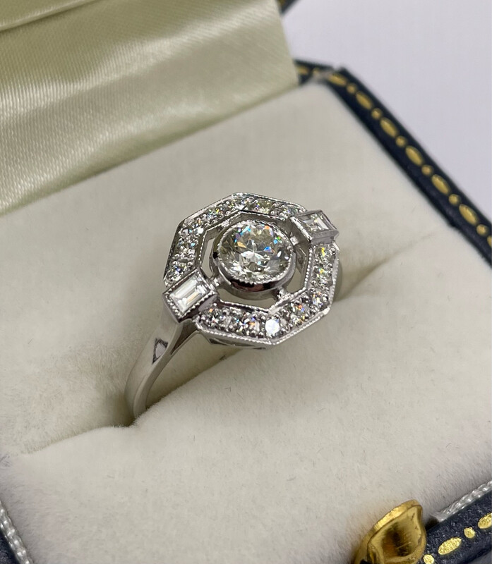 Deco Style Hexagonal Shaped Open Halo .95ct Diamond Ring. The Ring Is Set In Platinum With A Baguette Diamond To each Shoulder.