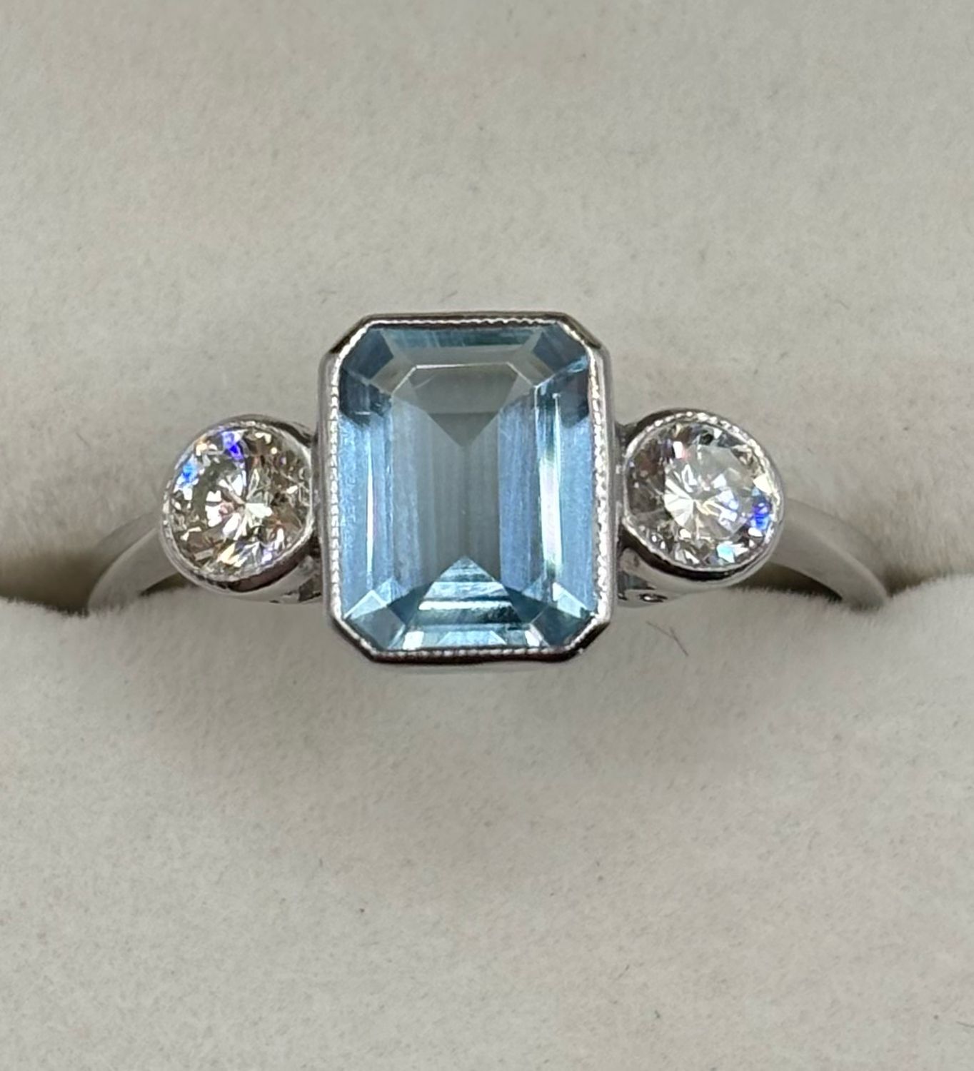 Platinum Three Stone Ring With 1.10ct Aquamarine And .40ct Brilliant Cut Diamonds In Rub Over Setting