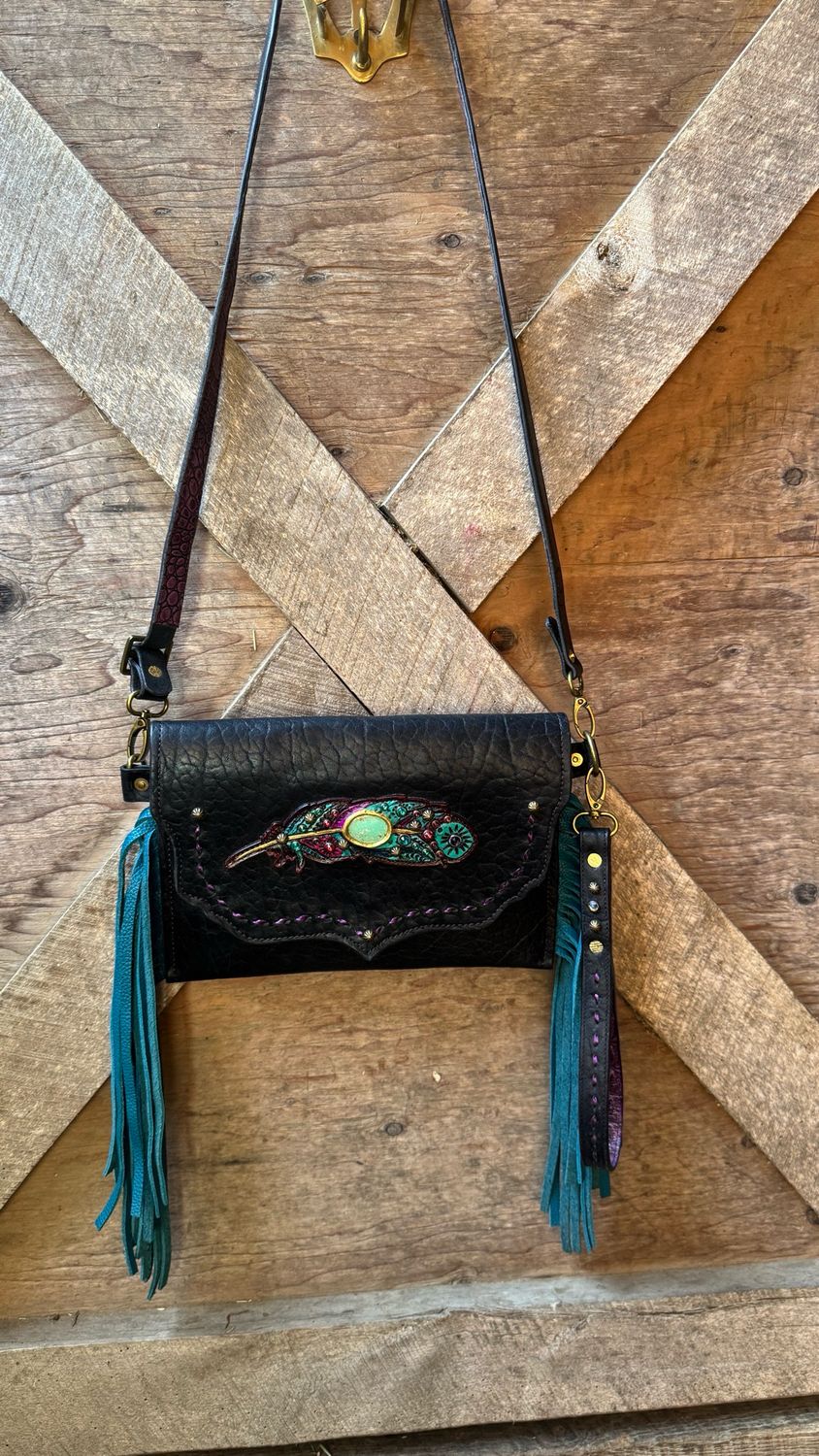 Black Leather Clutch/Crossbody, With Hand Painted Feather, With A Genuine Turquoise Cabachon Inlay. Crystal Rimsets And Antique Brass Spots Accent The Body And The Straps. Chap Grade Teal Fringe.