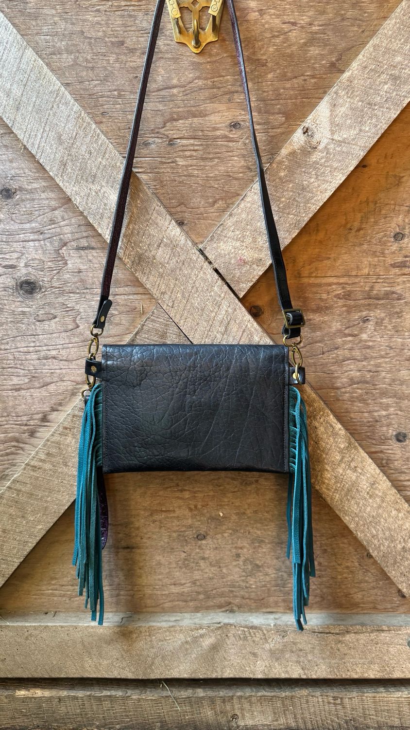 Black Leather Clutch/Crossbody, With Hand Painted Feather, With A Genuine Turquoise Cabachon Inlay. Crystal Rimsets And Antique Brass Spots Accent The Body And The Straps. Chap Grade Teal Fringe.