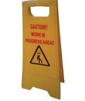 Yellow warning shaped sign printed  ,"CAUTION WORK IN PROGRESS OVERHEAD  CAUTION WORK IN PROGRESS AHEAD"