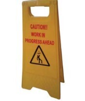 Yellow warning shaped sign printed ,"CAUTION WORK IN PROGRESS OVERHEAD CAUTION WORK IN PROGRESS AHEAD"