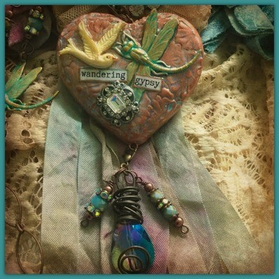 "Wandering Gypsy" - Clay and metal mixed media heart, bird, dragonfly and vintage rhinestone button necklace with "wandering gypsy" sealed in the heart.
