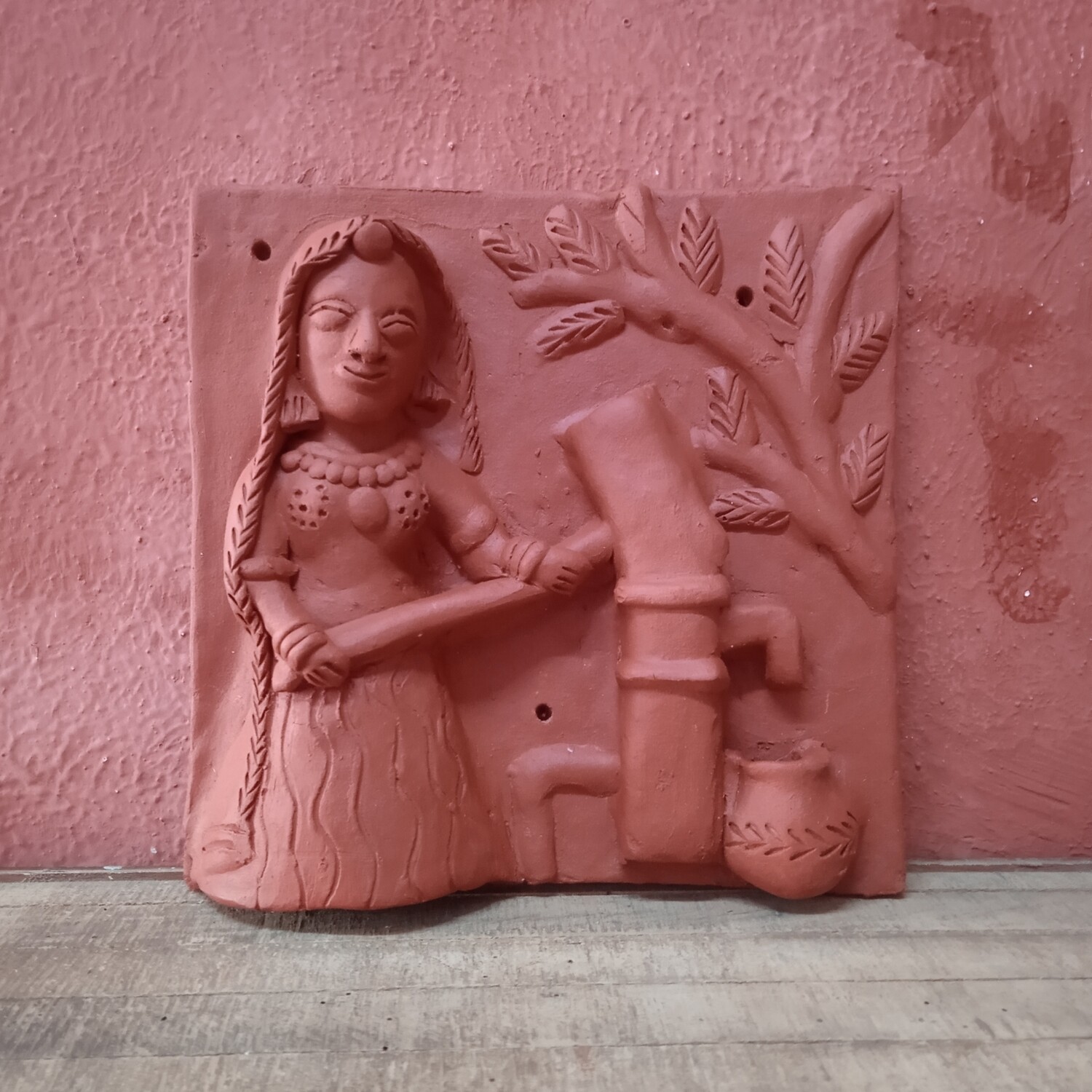 Terracotta woman at hand pump
