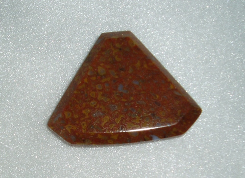 Baroque shaped dino bone cab of rust, yellow, and grey
