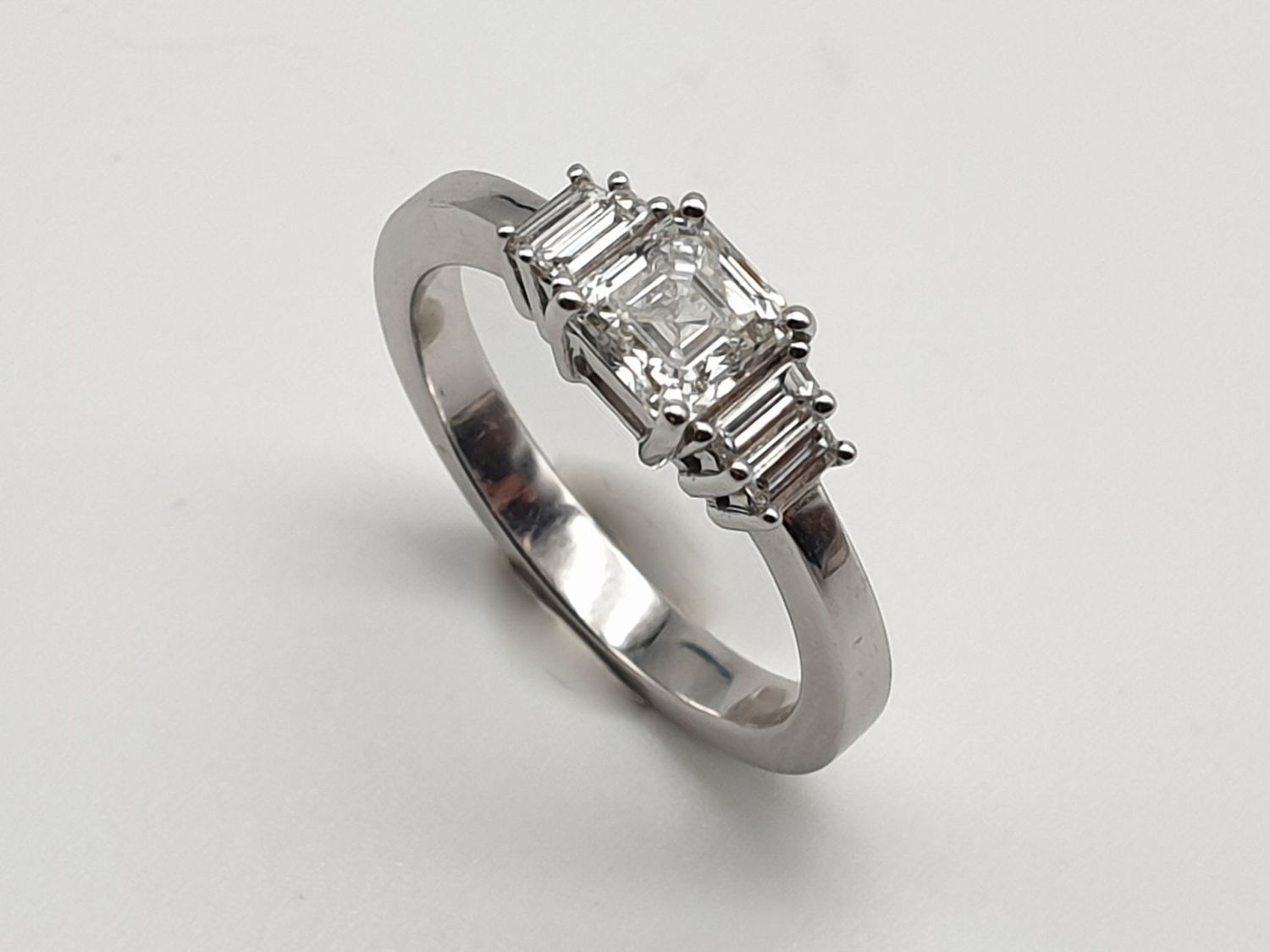 Anello in oro bianco con Diamante taglio Square Emerald ct. 0.80 e                   4 diamanti laterali ct. 0,30