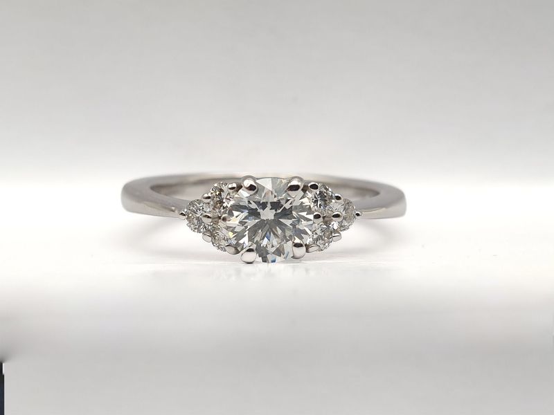 Anello in oro bianco Diamante naturale ct 0.60 e 6 diamanti laterali ct 0.22