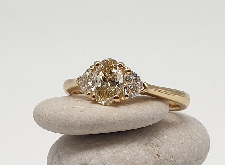 Anello in Oro Giallo con Diamante Ovale ct 0.60 e due diamanti laterali taglio a cuore