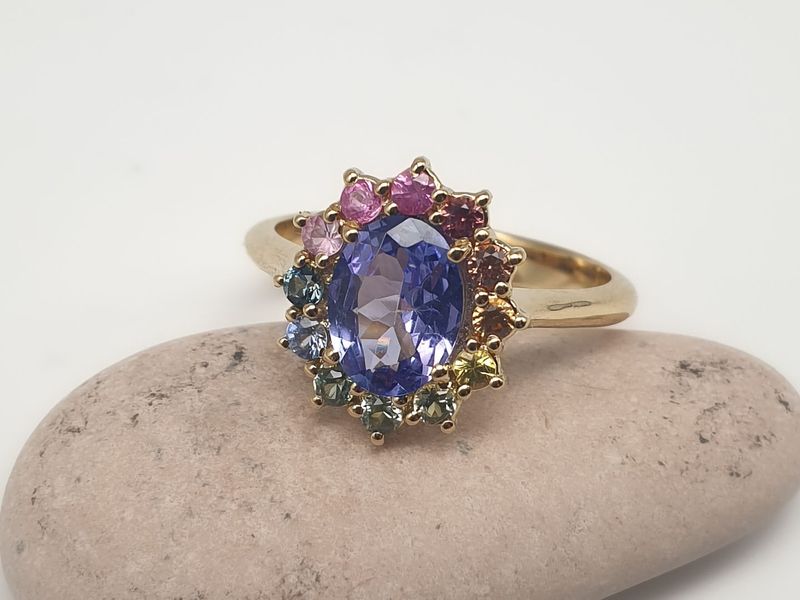 Anello in oro giallo con Tanzanite taglio Ovale ct 1.07 e controno di zaffiri multicolor ct 0.42