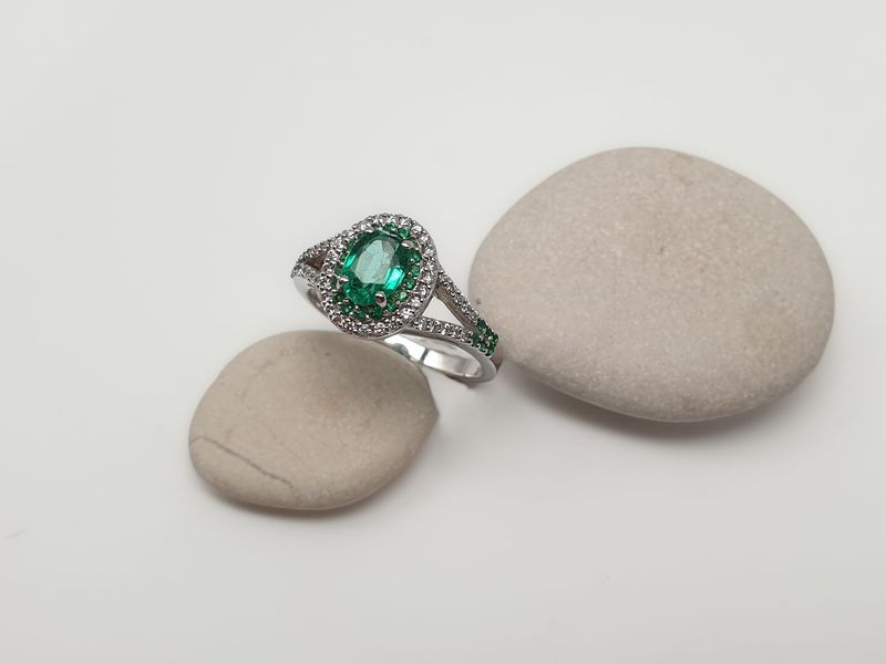 Anello in oro bianco con Smeraldo centrale ct 0.60 e contorno di diamanti e smeraldi naturali