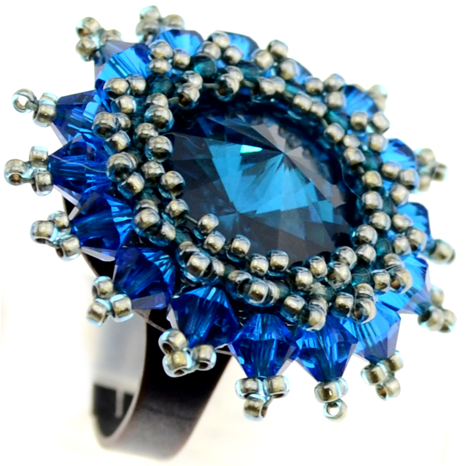 Handgefertigter Statement-Ring mit facettiertem Kristall in Tiefblau, umgeben von filigraner Perlenfassung in Silber- und Saphirtönen – aus der Perlenburg Legends Kollektion.