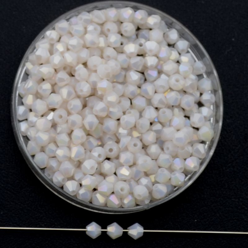 Doppelkegel-Kristallglasperlen – Roséweiß AB-Effekt, 3 mm I 40 Stück Facettierte Glasperlen in Roséweiß, Bicone-Schliff, 3 mm, mit feinem AB-Schimmer auf schwarzem Hintergrund