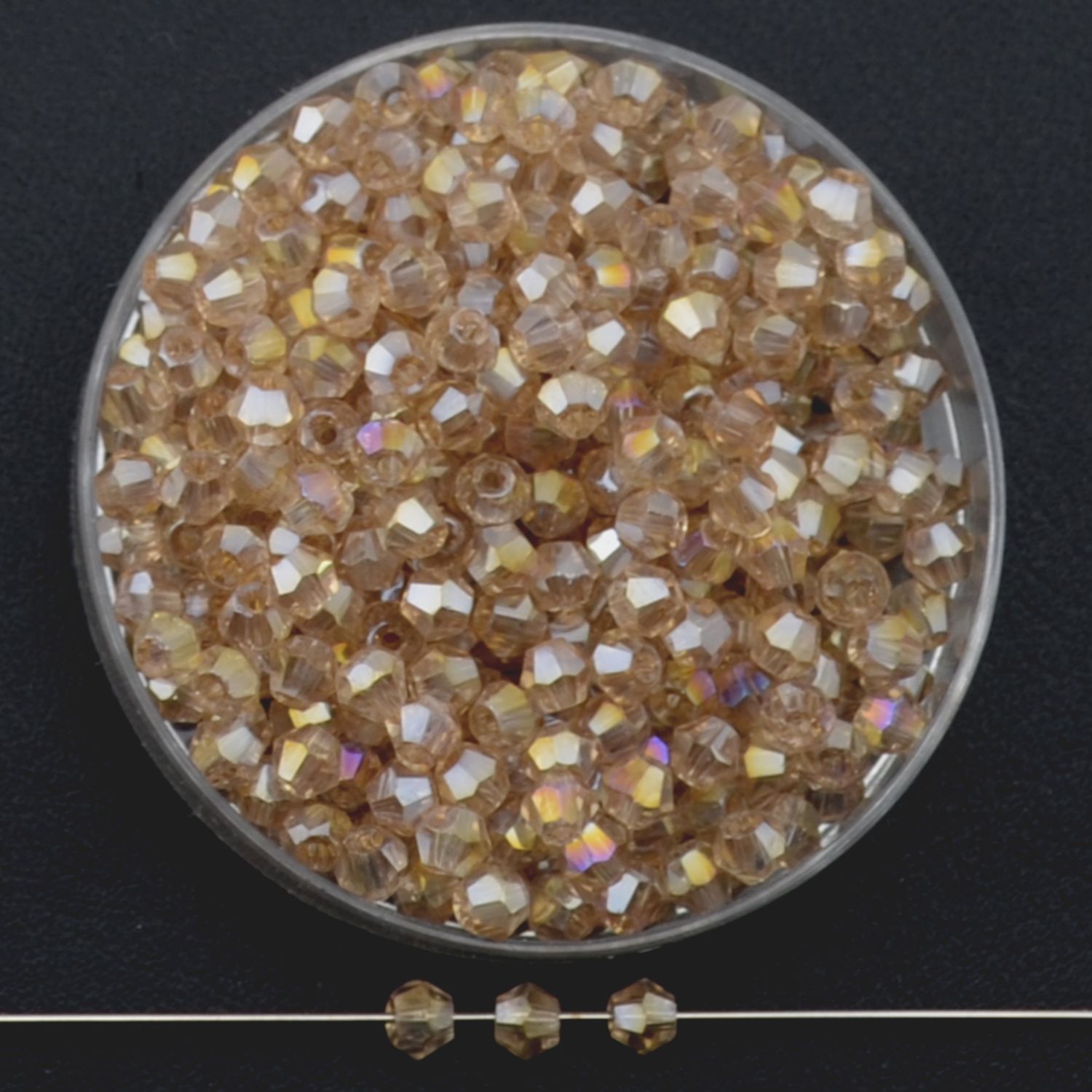 Facettierte Glasperlen in Cognac, Bicone-Schliff, 3 mm, mit AB-Schimmer auf schwarzem Hintergrund