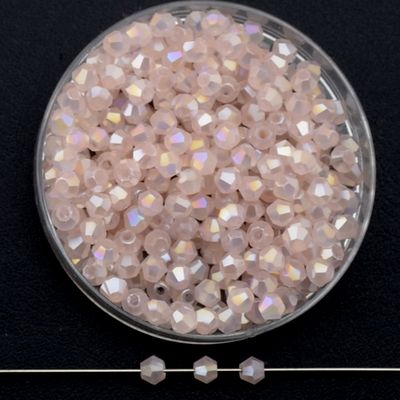 Facettierte Glasperlen in Puderrosa, Bicone-Schliff, 3 mm, mit AB-Schimmer auf schwarzem Hintergrund