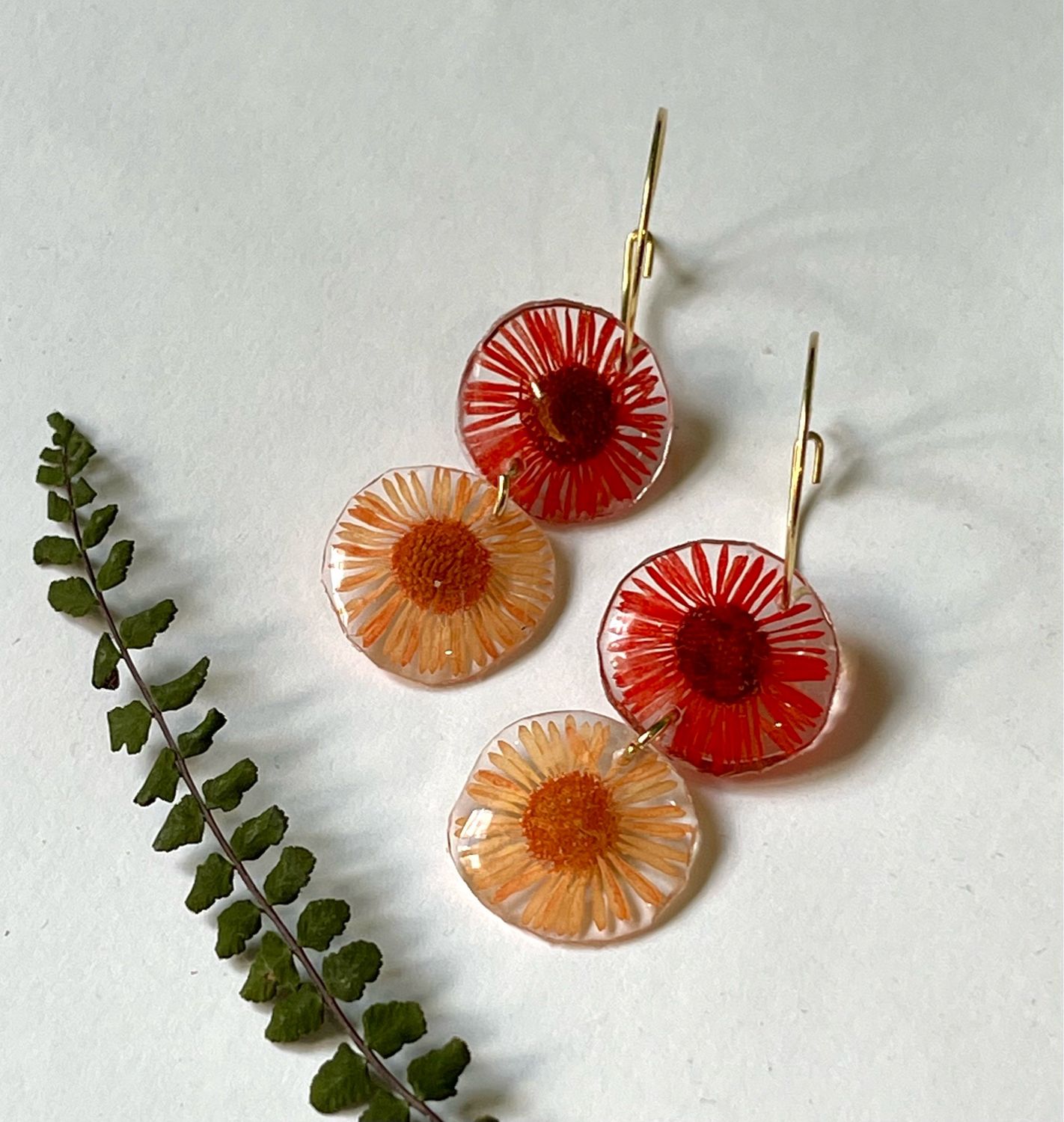 Aros dorados margaritas naranjas y rojas