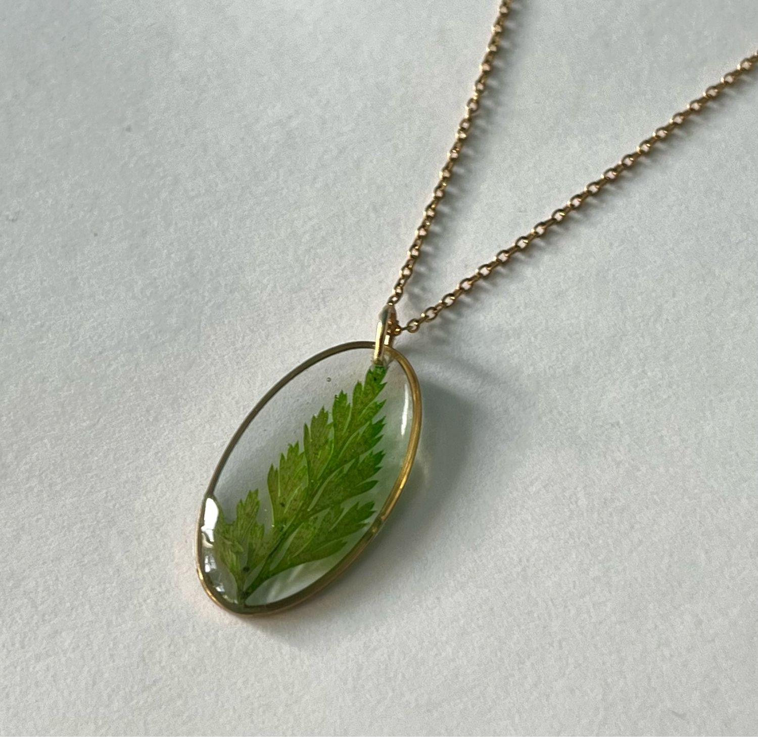 Collar óvalo dorado flor verde