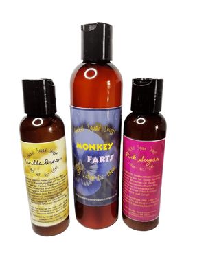 A set of three lotion bottles arranged side by side—on the left, a small bottle with a yellowish label; in the center, a larger bottle with a blue label; and on the right, a small bottle with pink wraparound labels.
