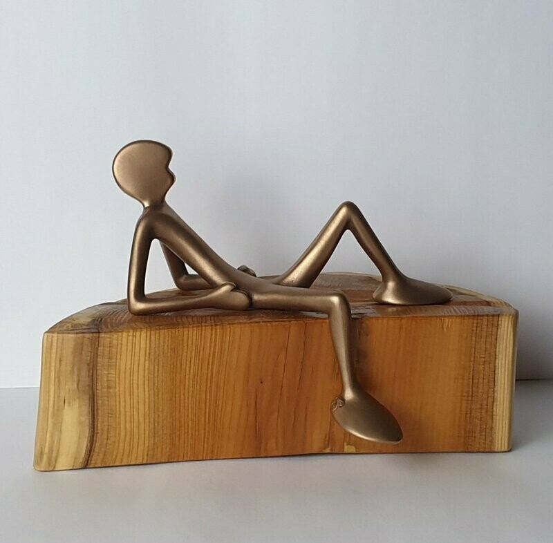 Das Bild zeigt  die Bronzeskulptur "Kleiner liegender Friend mit Eibenholzsockel" von Bildhauer Oliver Pohl aus Haste.