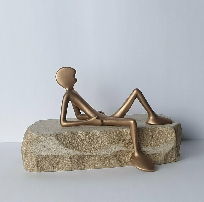 Das Bild zeigt  die Bronzeskulptur "Kleiner liegender Friend mit Steinsockel" von Bildhauer Oliver Pohl aus Haste.