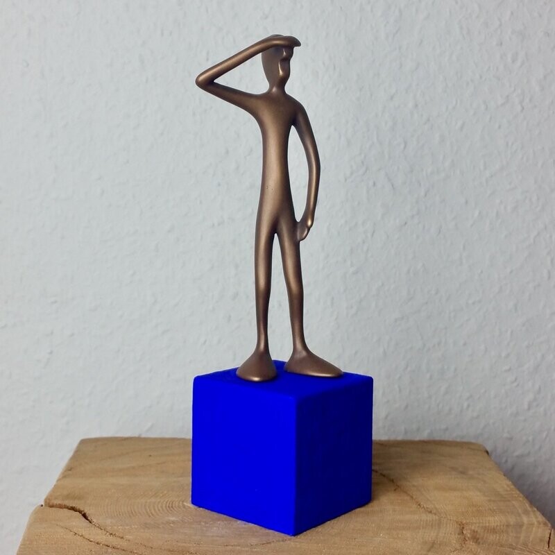 Das Bild zeigt  die Bronzeskulptur "Kleiner stehender Friend  mit blauem Sockel" von Bildhauer Oliver Pohl aus Haste.