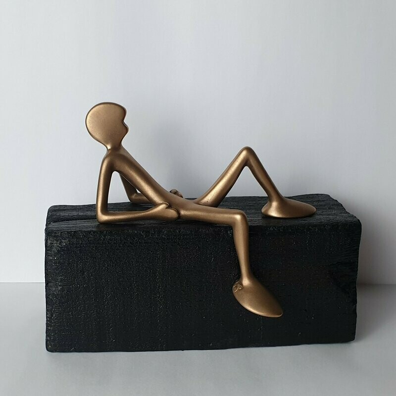 FRIEND No 3, 'Lümmler mit Sockel burned wood' Das Bild zeigt die Bronzeskulptur "Kleiner liegender Friend mit schwarzem Sockel" von Bildhauer Oliver Pohl aus Haste.