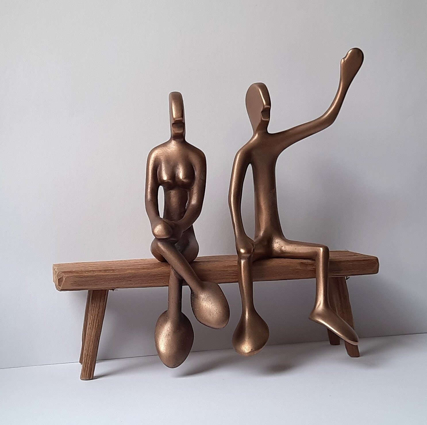 Das Bild zeigt  zwei Bronzeskulpturen "Friendsgirl mit Friend auf einer Bank sitzend" von Bildhauer Oliver Pohl aus Haste.