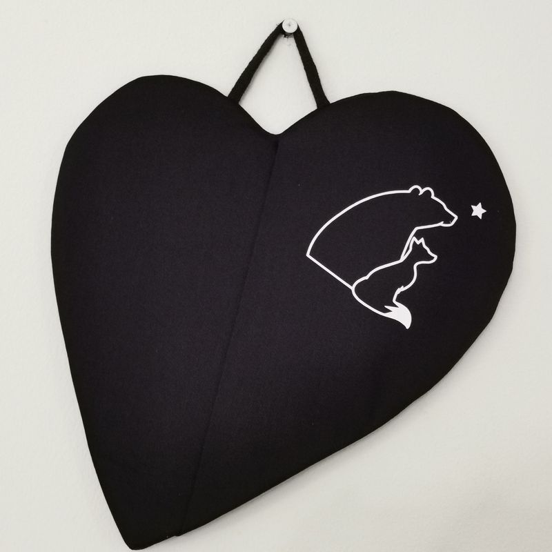 Musta taskullinen patalappu, joka suojaa &quot;pellin alapuolisia&quot; sormia palovahingoilta.