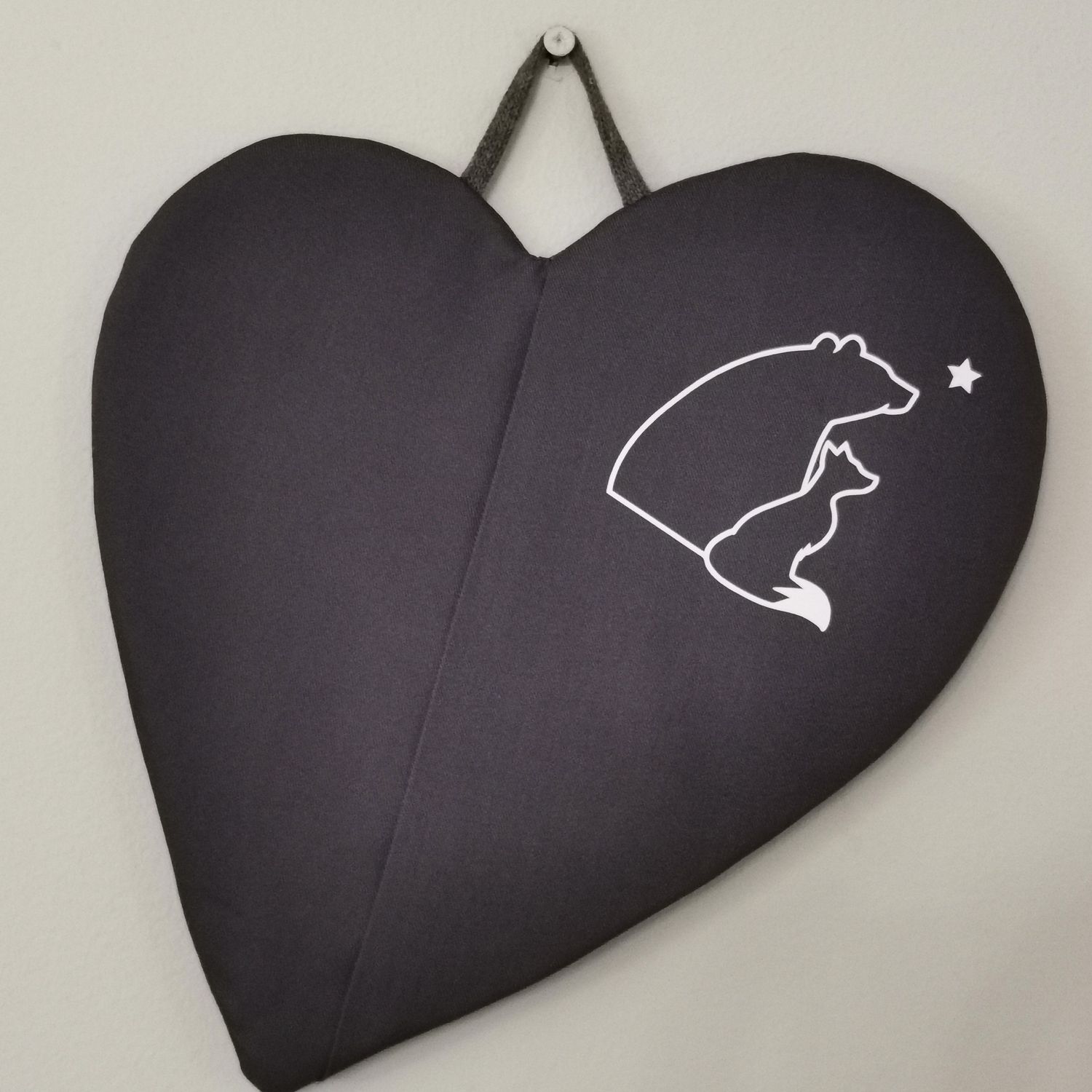 Tummanharmaa taskullinen patalappu, joka suojaa &quot;pellin alapuolisia&quot; sormia palovahingoilta.