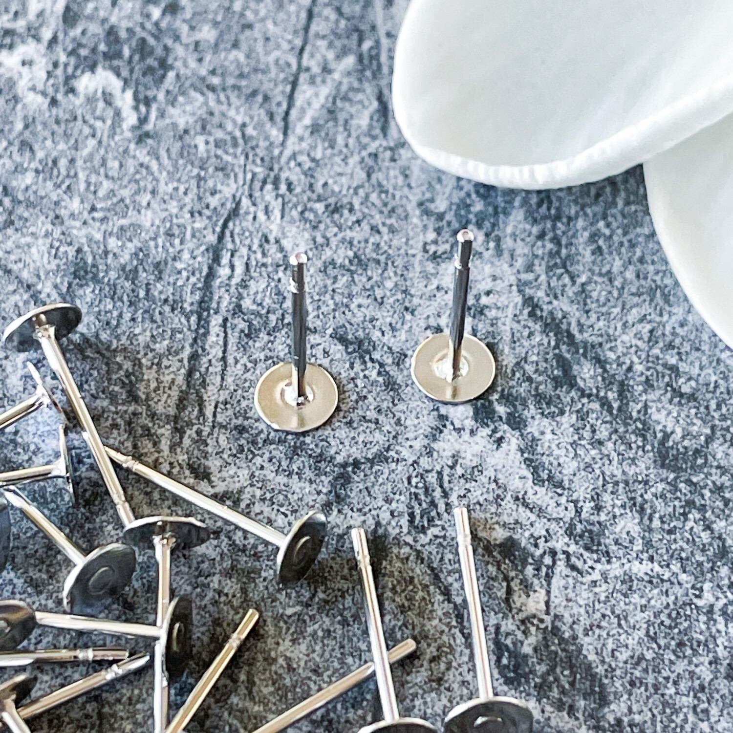 Earring Posts 4mm Flat Pad WITH EAR NUTS - Stainless Steel. Sold per pkg of 10 pairs.