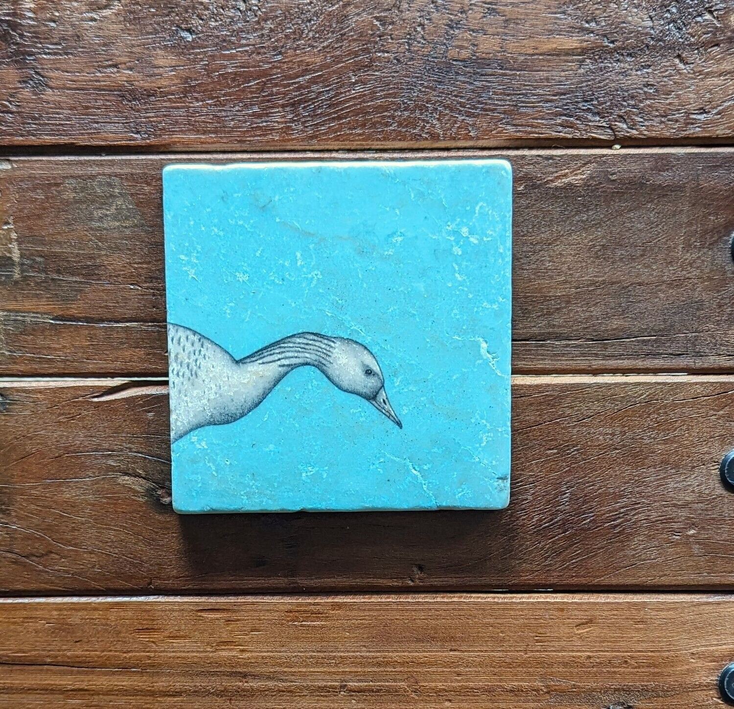 Dekofliese/Untersetzer Gans auf eisblauem Hintergrund, Keramik; Künstlerarbeit, Zeichnungen werden mit einer Drucktechnik auf die Fliese aufgebracht; 10 x 10cm