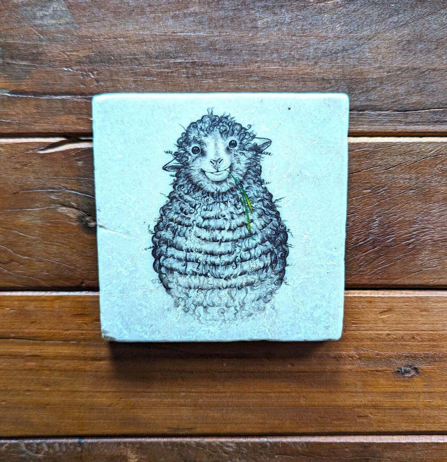 Dekofliese/Untersetzer Schaf mit Grashalm auf cremefarbenem Hintergrund, Keramik; Künstlerarbeit, Zeichnungen werden mit einer Drucktechnik auf die Fliese aufgebracht; 10 x 10cm