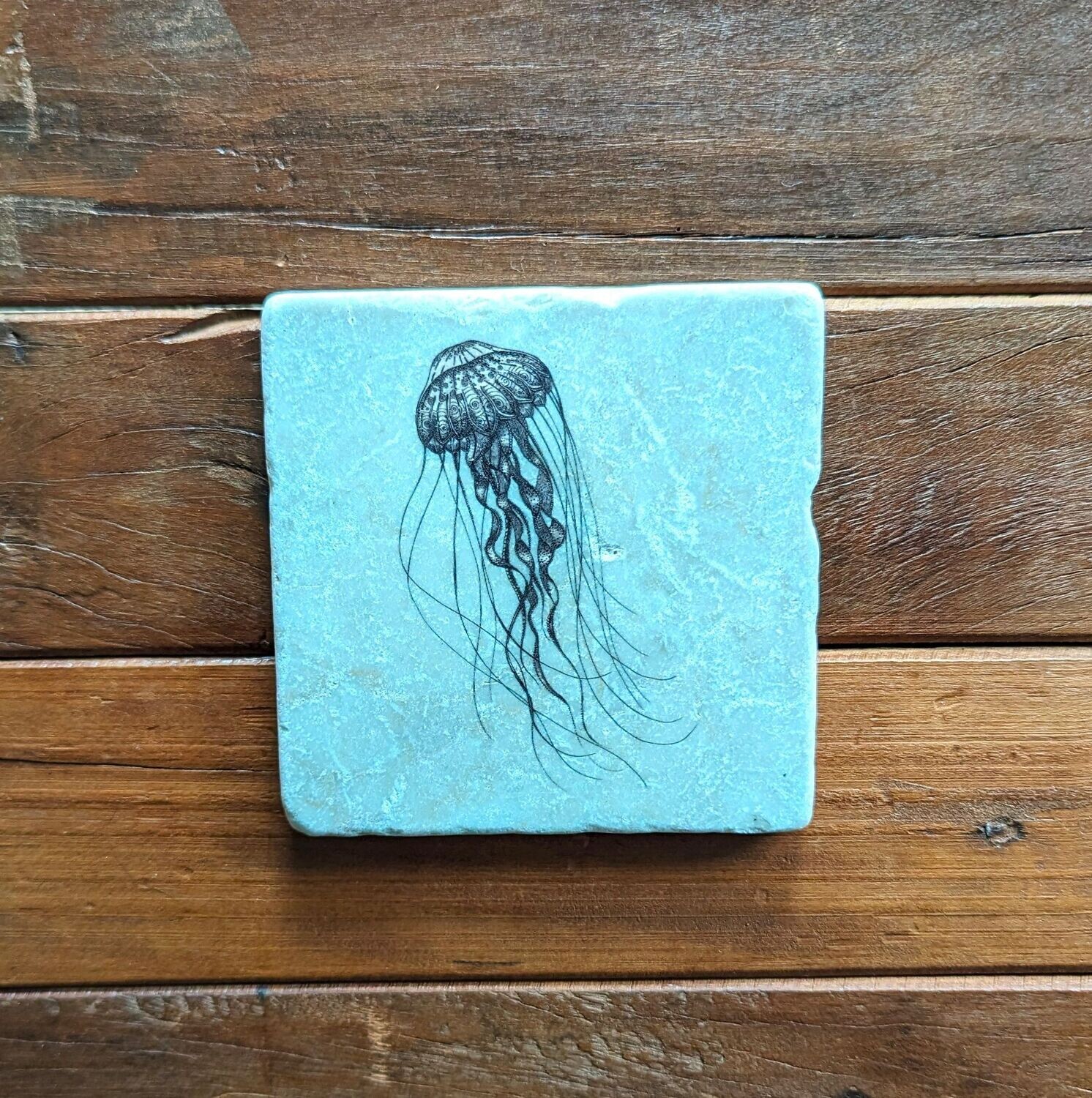 Dekofliese/Untersetzer Qualle auf eisblauem Hintergrund, Keramik; Künstlerarbeit, Zeichnungen werden mit einer Drucktechnik auf die Fliese aufgebracht; 10 x 10cm