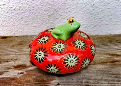 Schwimmlinse Porzellan mit Froschkönig, erdbeerrot/apfelgrün; H8cm dm10cm;