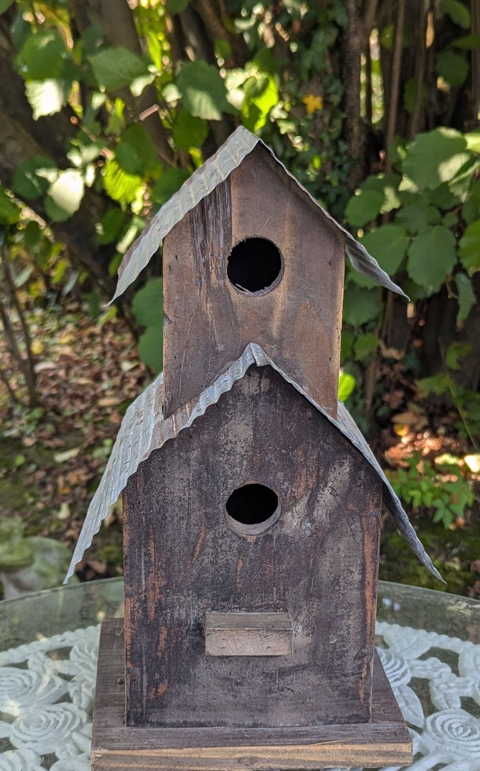 Vogelhaus Holz mit Wellblechdach; zum Aufhängen; mit Türe hinten und kleiner Sitzplatzvorrichtung vorne unter dem unteren Einflugsloch; H36cm B bis 20cm T17,5cm