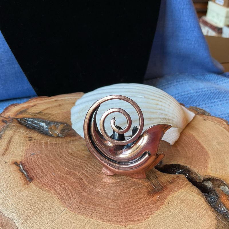 Hand-wrought abstract form, unsigned rare stud.	Copper swirls shaped by hand—abstract grace forged in quiet rarity.	