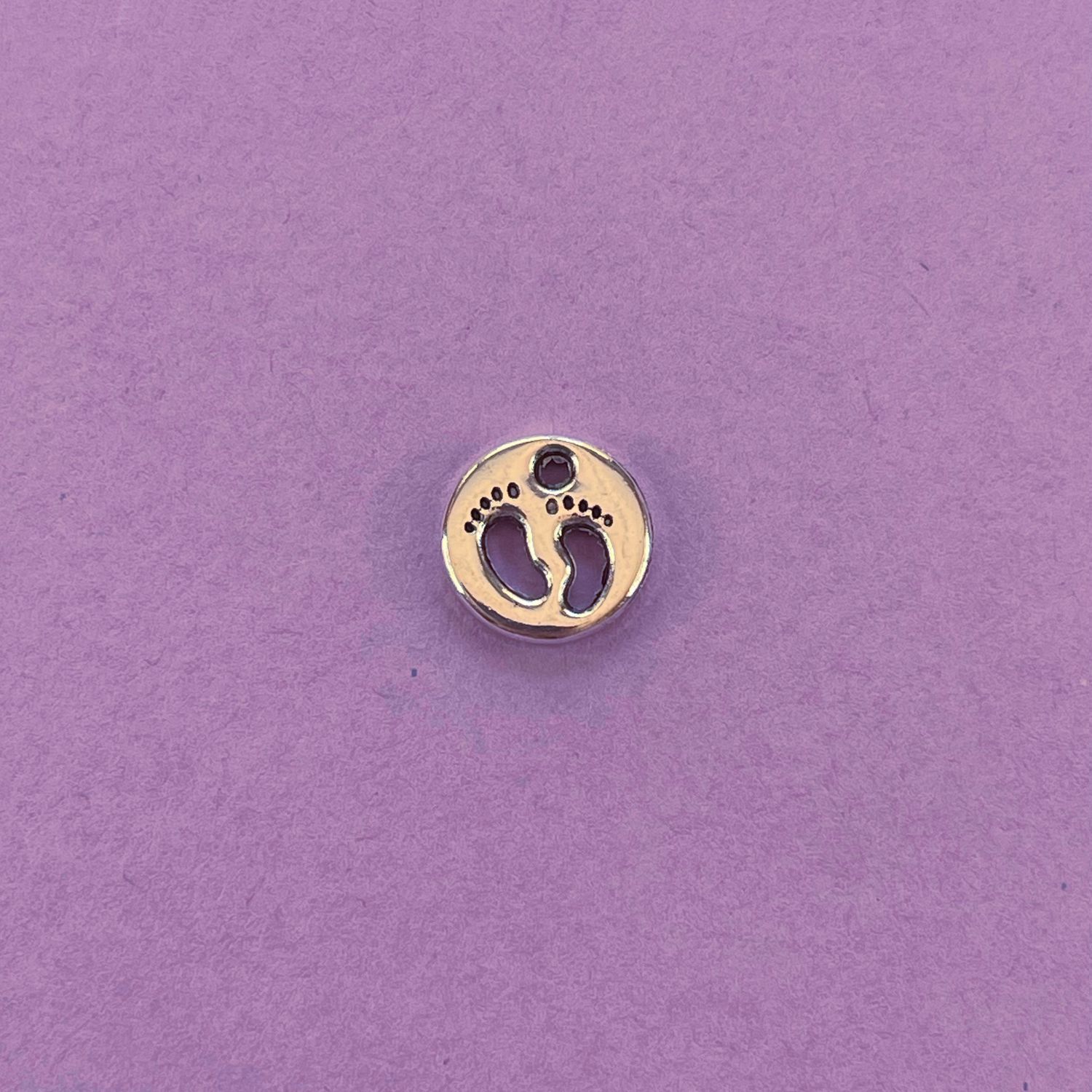 Dije de Metal Plateado Redondo Calado Huellitas Pie Bebé 11 x 2 mm