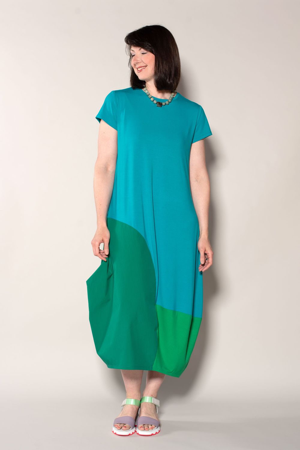 The Edgewater Dress made in blue and green jersey knit, with a green woven side panel. 