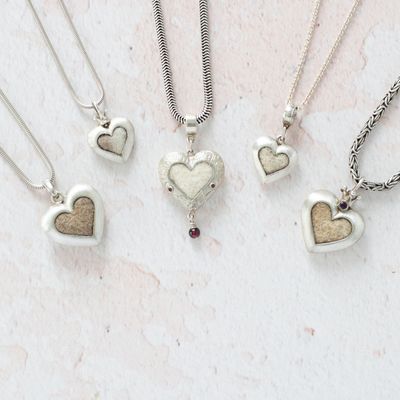 drei große und zwei etwas kleinere symmetrische Herzen mit Tierhaaren in unterschiedlicher Ausführung