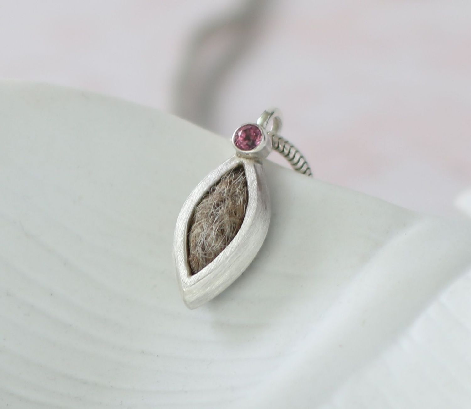 eleganter navetteförmiger Kettenanhänger aus Silber mit Tierhaaren und einem funkelnden Edelstein an der oberen Spitze