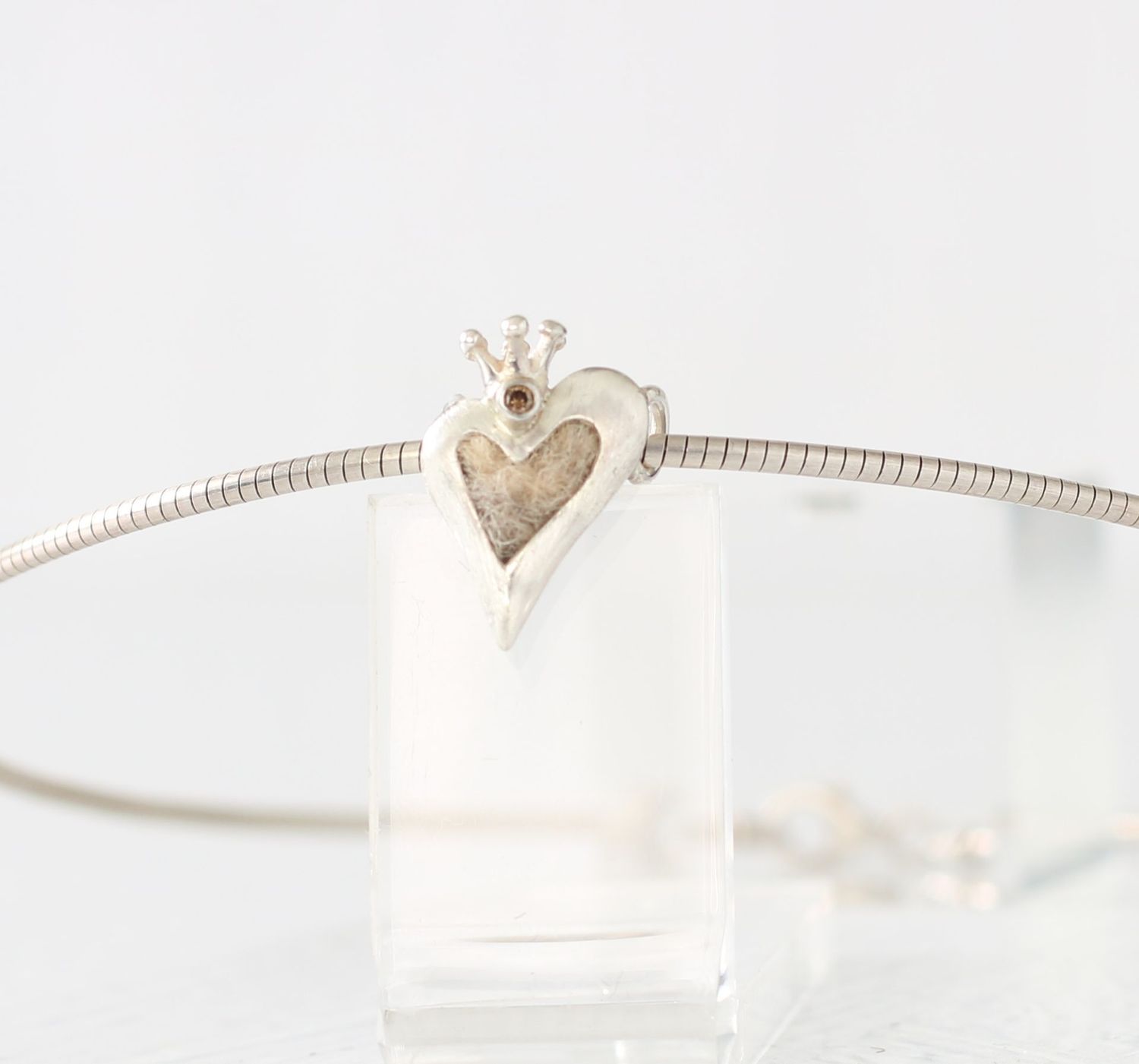 elegantes Silberherz mit Krone und Edelstein mit Tierhaaren