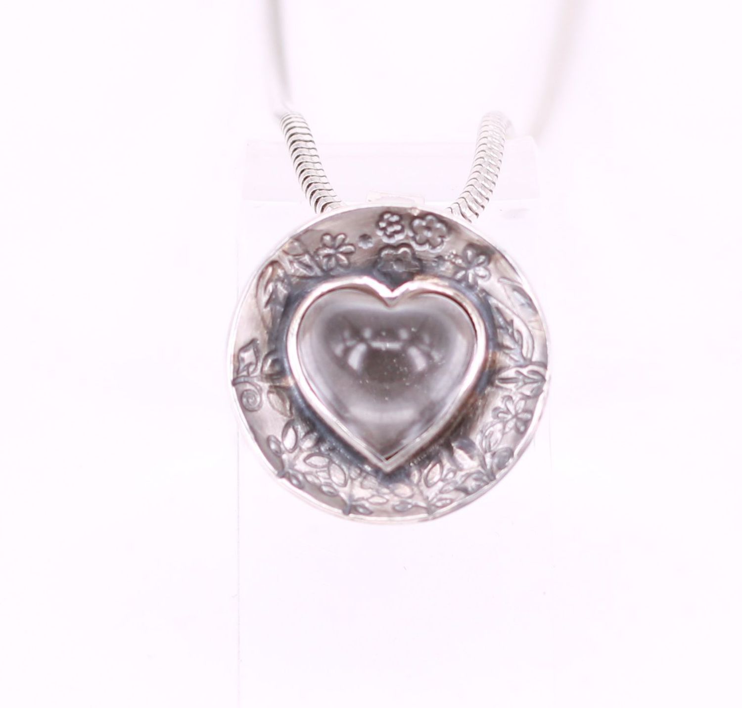 Bergkristallherz in Schale mit floraler Punzierung Bergkristall in Herzform mit blumendesign